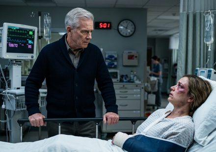 A 67-year-old father standing beside his daughter in the ICU after discovering her serious injuries.