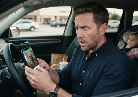 Shocked husband looking at a baby monitor app after he caught my wife cheating in their child's room.
