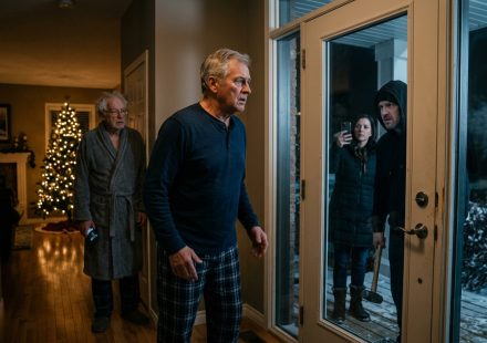 An elderly father stands inside his damaged doorway after his son demanded he sign the papers during a tense 1 a.m. visit.