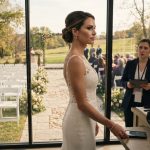 Bride calmly preparing beside a window overlooking 54 empty chairs at my wedding while the groom's guests gather on the opposite side.