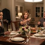 Savannah sits calmly at a Mother's Day dinner while her mother raises a glass and other family members laugh around the table.