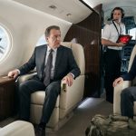 Woman sits calmly inside her rich uncle's luxury private jet as a worried pilot holds a red security screen and an F-22 appears outside.