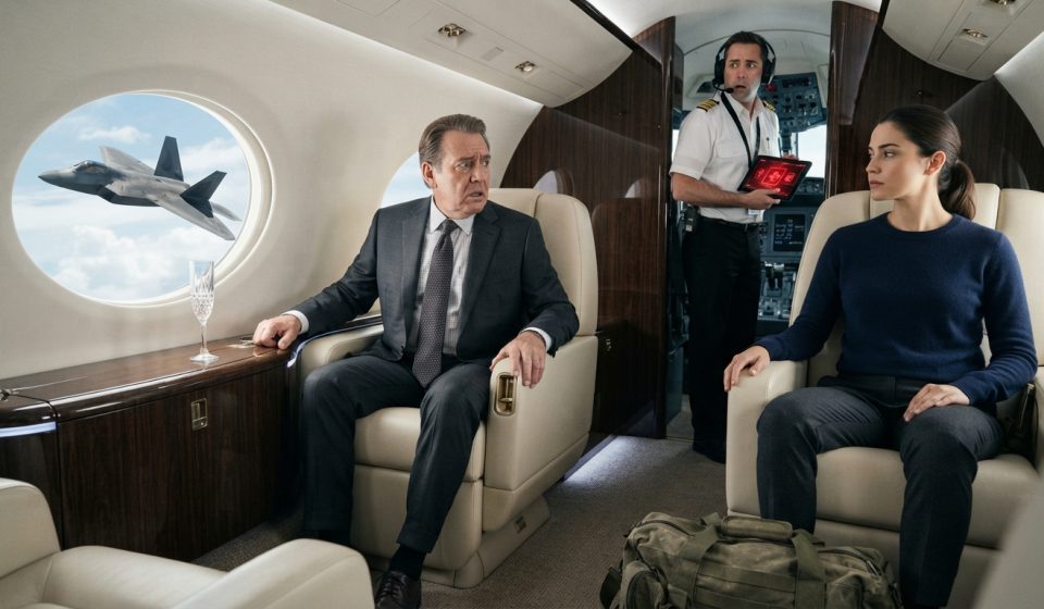 Woman sits calmly inside her rich uncle's luxury private jet as a worried pilot holds a red security screen and an F-22 appears outside.