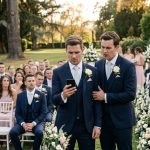 Groom checks his phone after his fiancée didn't show up to the altar while wedding guests wait behind him.