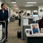 Woman discovering her husband's photo on a coworker's desk during her first day at a new military logistics office
