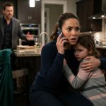 A protective mother holds her frightened eight-year-old daughter during a tense confrontation with her angry husband inside their home.