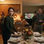Emma looks humiliated while setting the Thanksgiving table as her father records her on his phone and her siblings laugh in the background.