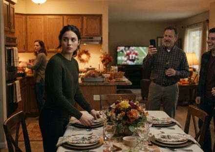 Emma looks humiliated while setting the Thanksgiving table as her father records her on his phone and her siblings laugh in the background.