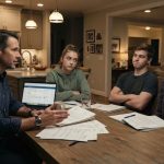 A stepfather discusses college costs with his two teenage stepchildren and their mother around the family kitchen table.
