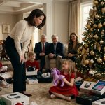 A five-year-old girl in a red Christmas dress holds a damaged purple plastic toy horse beside a decorated tree while other children open expensive gifts.