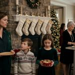 A mother and her two children stand near a Christmas fireplace with six stockings reserved for other family members.