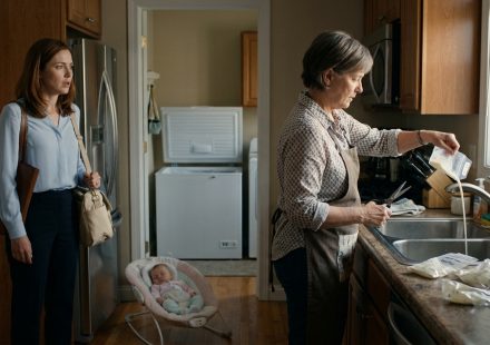 Shocked mother standing in her kitchen as her mother-in-law pours stored breast milk down the sink beside a pile of empty storage bags.