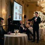 A 36-year-old man sits calmly at a luxurious wedding reception while his brother mocks him with a microphone and wealthy guests laugh at a humiliating presentation.