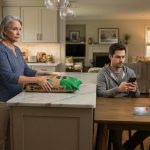 Crystal holding a heavy bag of potting soil while her son looks at his phone and his wife sits beside her silver debit card.