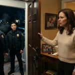 A grieving mother stands in the doorway of her family home as two police officers deliver devastating news about her husband and son.