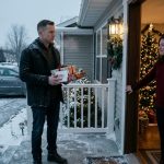 A disappointed man holding wrapped Christmas gifts stands outside his sister's warmly decorated house as she refuses to let him join the family celebration.