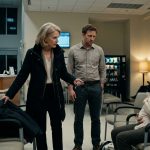 A worried young mother holds her feverish baby in a hospital emergency waiting room while her mother-in-law grips her husband's coat and demands that he leave.
