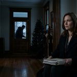 A successful woman sits in a dark historic mansion holding a document folder while her brother attempts to open the front door on Christmas Eve.