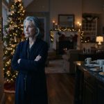 Older woman standing inside her empty Christmas home after her family left her alone on Christmas