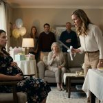 A pregnant woman sits in shock at her baby shower while her older sister holds a ribbon-decorated cake knife near the celebration table as relatives watch in alarm.