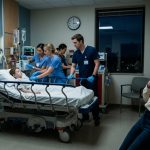 A terrified mother stands inside a pediatric intensive care unit holding her phone while doctors urgently treat her seven-year-old son during a cardiac emergency.